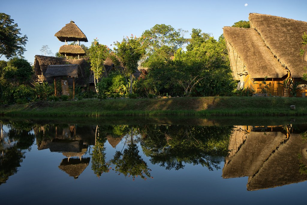 Canoa navegando al amanecer por un río de la Amazonía ecuatoriana